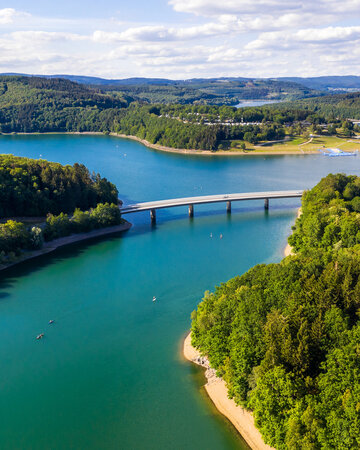 Aerial view of Biggesee lake with shoreline and bridge in South Westphalia.